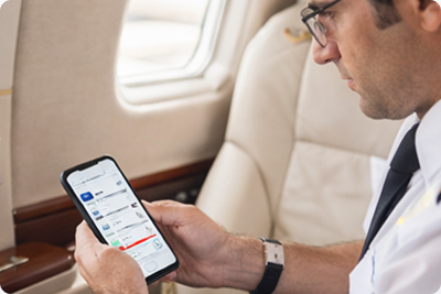 Pilot checking FlightApp on his phone in a business jet cabin
